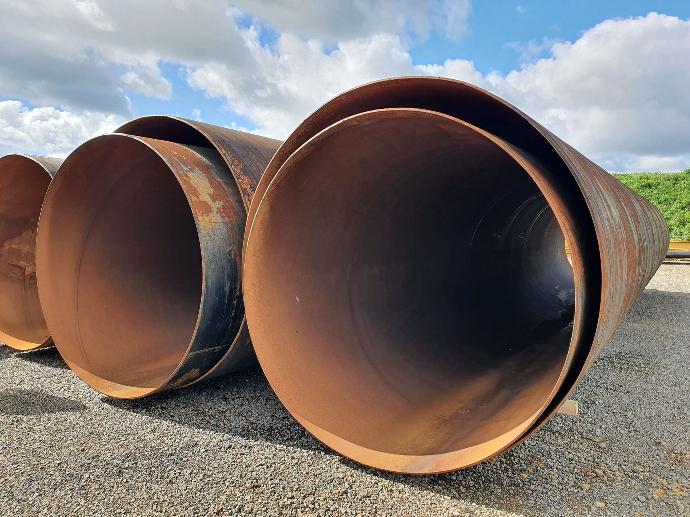 Close-up of industrial pipes, showing a smooth metal surface and connections in a factory setting